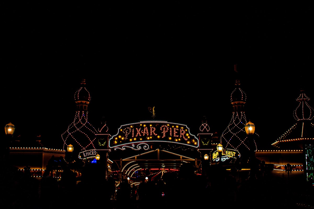 Strings of lights outline the Pixar Pier entrance at night.